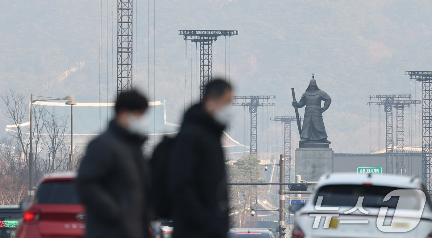 (서울=뉴스1) 박지혜 기자 = 미세먼지 비상저감조치가 발령된 17일 오전 서울 중구 시청역 앞에서 출근하는 시민들 뒤로 도심이 뿌옇게 보이고 있다. 2026.3.17/뉴스1