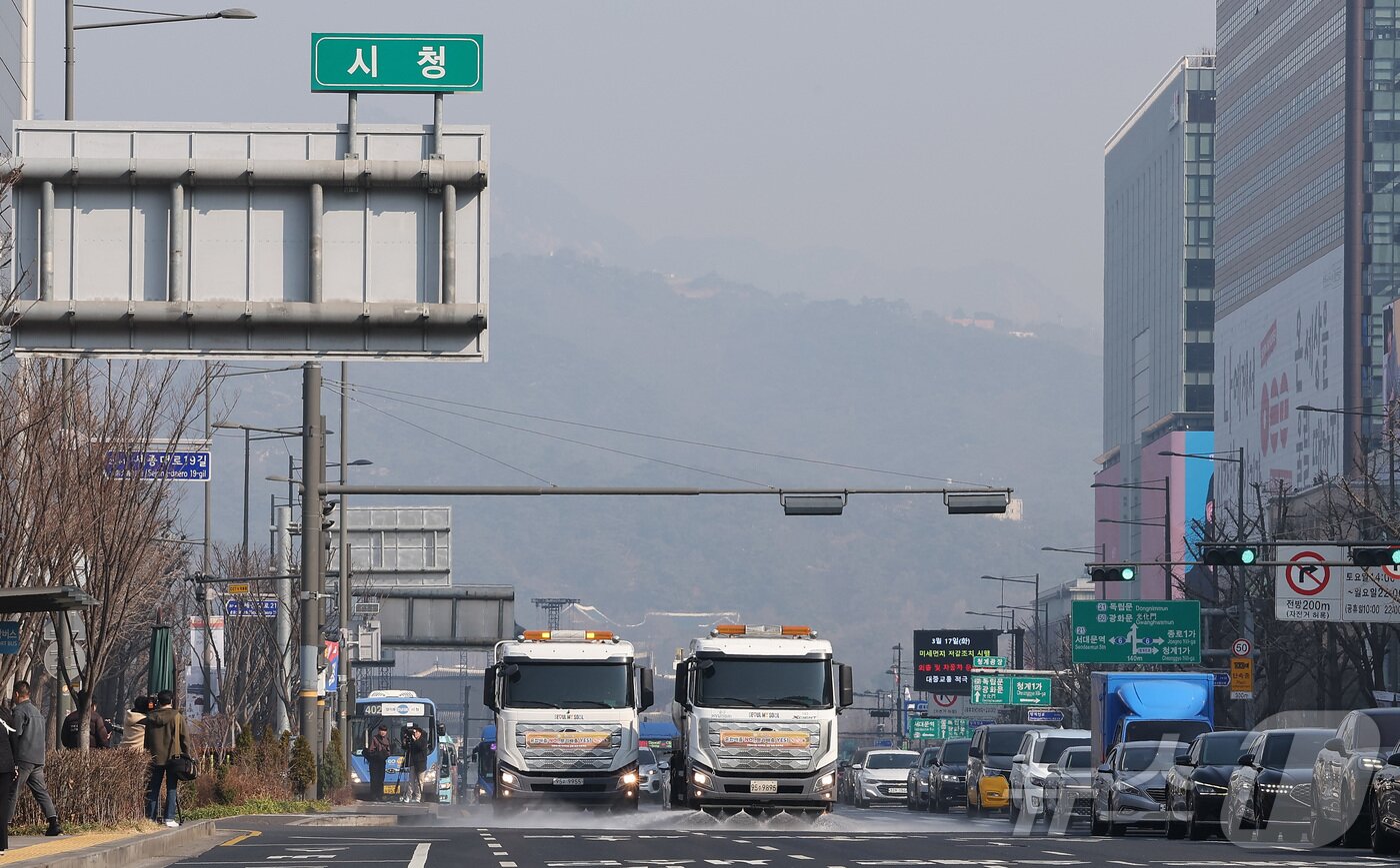 본문 이미지 - 수도권과 충남 지역에 초미세먼지 재난위기경보 '관심' 단계가 발령되면서 비상저감조치가 시행된 17일 오전 서울 중구 세종대로에서 중구 관계자들이 청소 차량을 이용해 도로 물청소를 하고 있다. ⓒ 뉴스1 김성진 기자