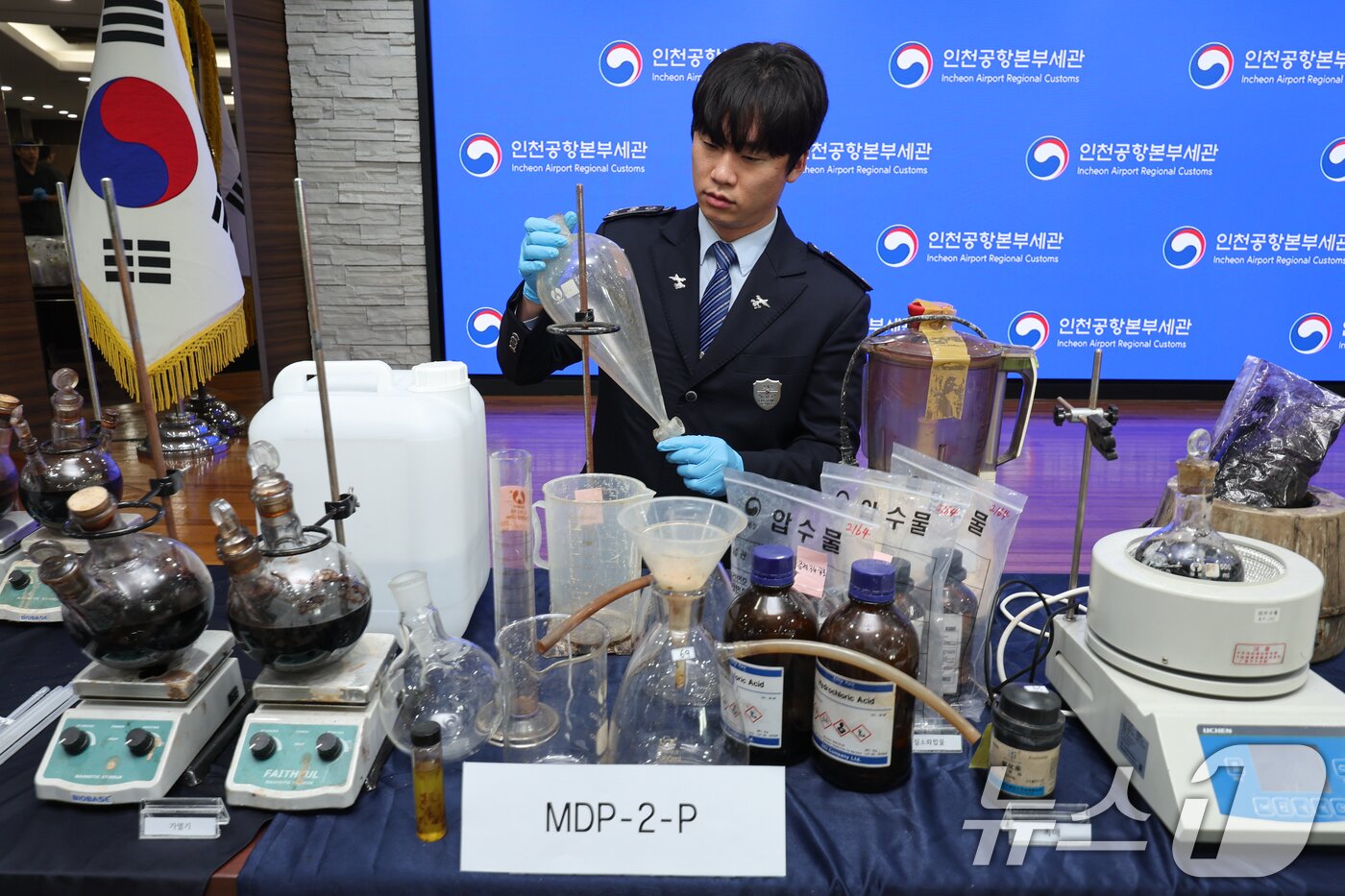 본문 이미지 - 17일 인천 중구 인천공항본부세관 수출입통관청사에서 직원이 국내 항정신성 마약 MDMA(엑스터시) 제조 시설 적발 및 유통일당 검거와 관련, 압수품을 들어 보이고 있다. 2026.3.17 ⓒ 뉴스1 안은나 기자