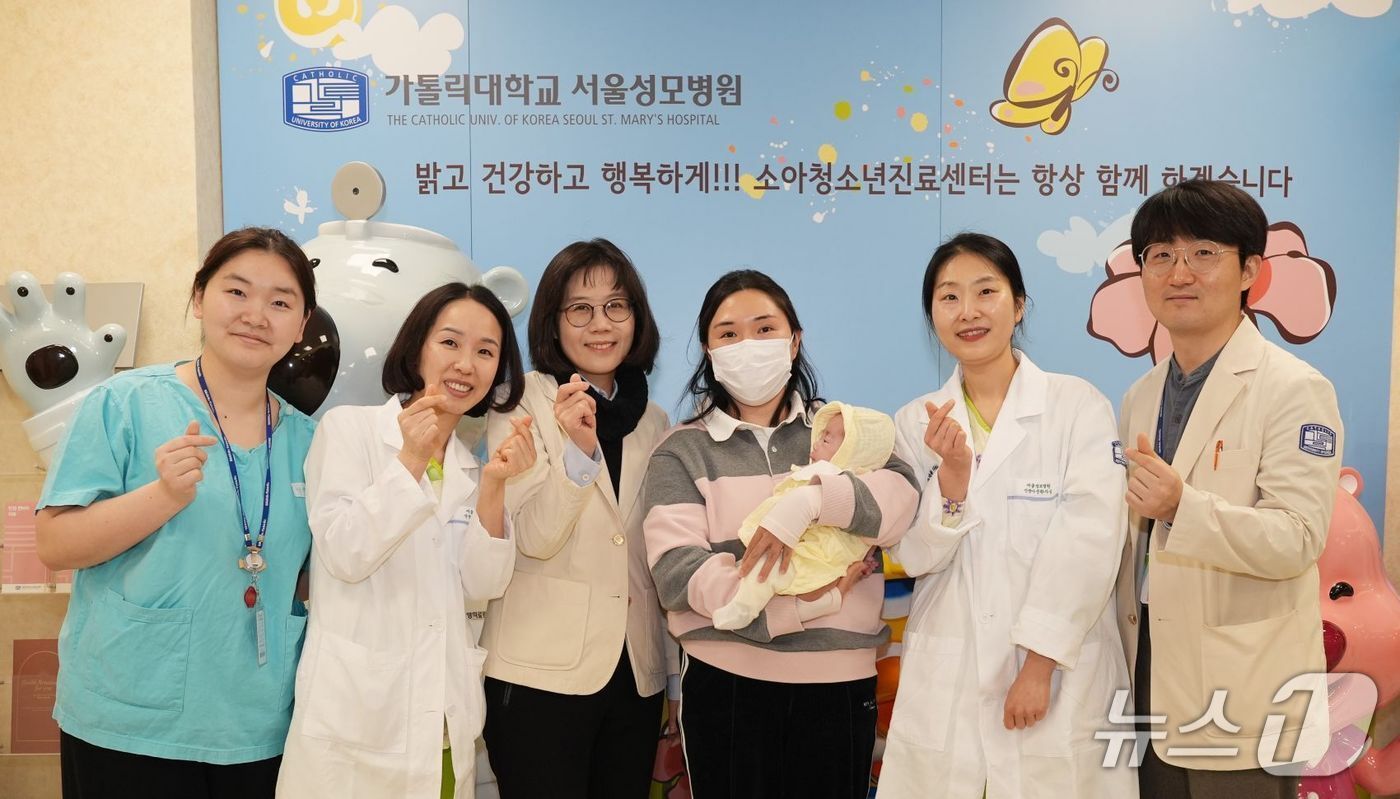 본문 이미지 - 주하 양의 퇴원을 기념하는 서울성모병원 의료진과 주하 양의 어머니.(가톨릭대 서울성모병원 제공)