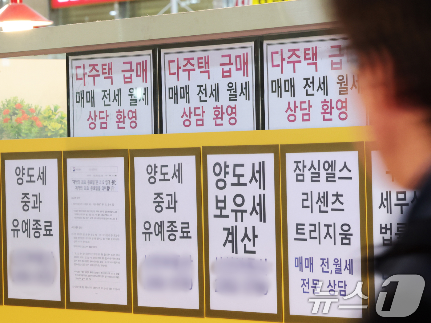 (서울=뉴스1) 황기선 기자 = 17일 서울 시내의 한 공인중개사 사무소 앞을 시민들이 지나가고 있다.정부가 집값 안정을 위해 세제와 금융 등을 아우르는 강력한 수요 억제 대책을 …