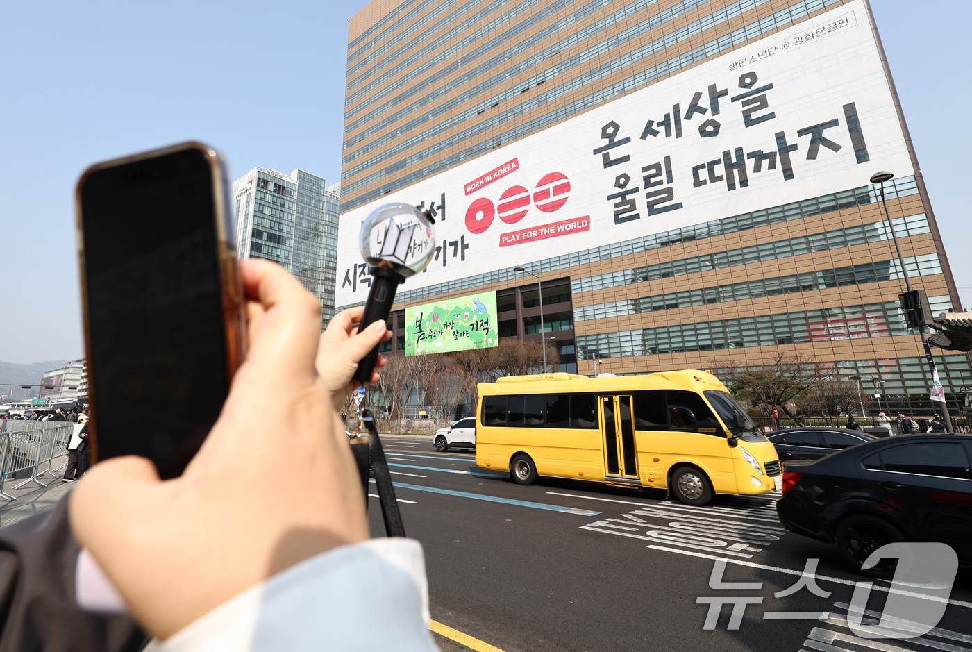 (서울=뉴스1) 최지환 기자 = 방탄소년단(BTS) 컴백 공연을 앞둔 17일 서울 종로구 광화문광장에서 한 팬이 교보생명빌딩 광화문글판에 걸린 BTS 컴백 문구를 배경으로 기념촬영 …