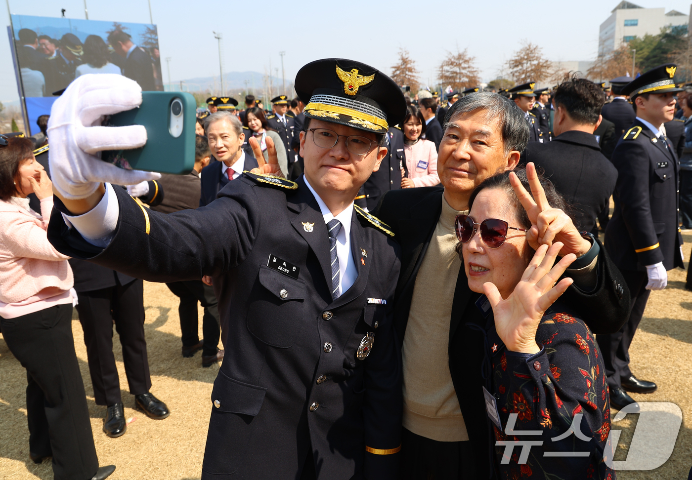 (아산=뉴스1) 허경 기자 = 17일 충남 아산 경찰대학 본관 앞 잔디광장에서 열린 신임 경찰 경위·경감 임용식에서 한 임용자가 계급장 부착 후 가족과 기념촬영을 하고 있다. (청 …