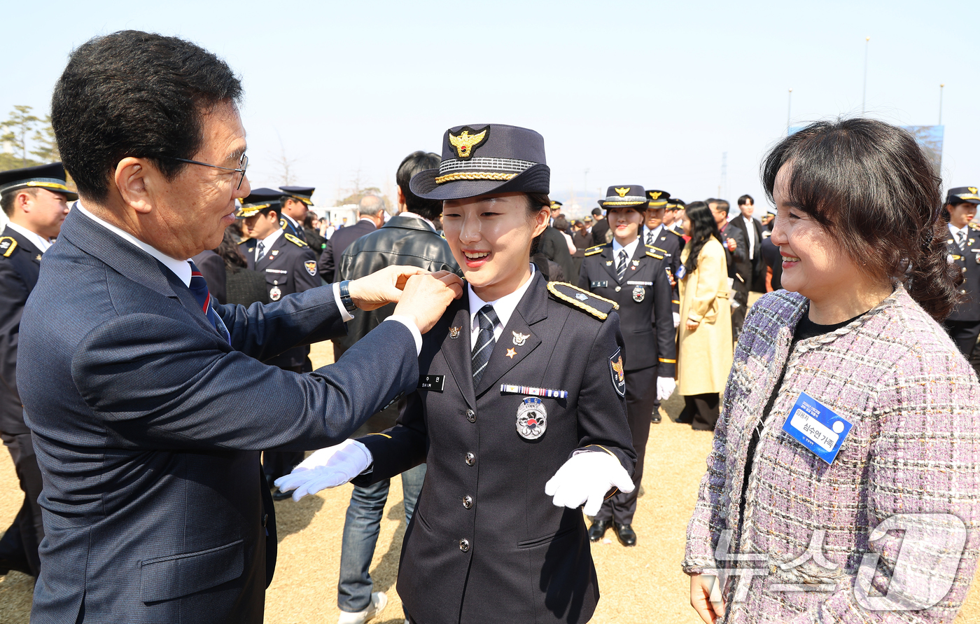 (아산=뉴스1) 허경 기자 = 17일 충남 아산 경찰대학 본관 앞 잔디광장에서 열린 신임 경찰·경감 임용식에서 신정훈 국회 행안위원장이 심수연 신임 경위에게 계급장을 부착해주고 있 …