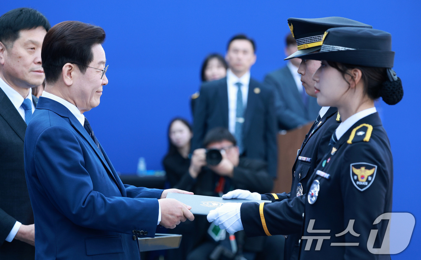 (아산=뉴스1) 이재명 기자 = 이재명 대통령이 17일 충남 아산시 경찰대학에서 열린 신임 경찰 경위·경감 임용식에서 송민건 경위에게 상장을 수여하고 있다. (청와대통신사진기자단) …