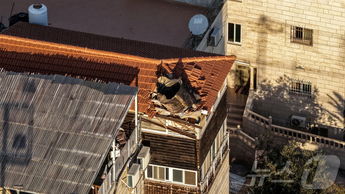 (예루살렘 로이터=뉴스1) 권영미 기자 = 16일 미·이스라엘과 이란 간 충돌 속에 동예루살렘의 한 건물 옥상에 떨어진 이란 미사일 잔해가 드론 카메라에 포착됐다. 2026.03. …