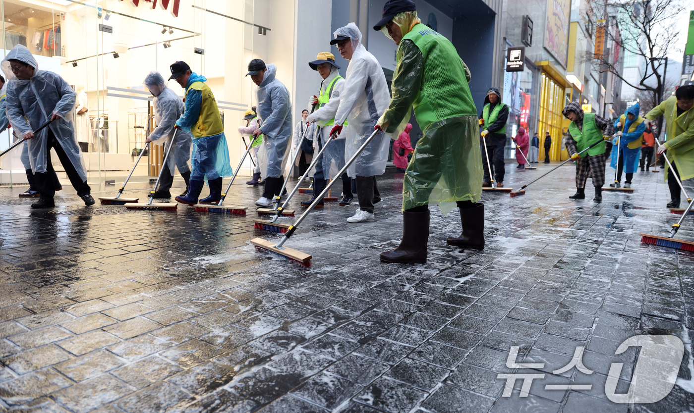 (서울=뉴스1) 김명섭 기자 = 18일 서울 중구 명동에서 중구청 직원 및 상인들이 오는 21일 열리는 BTS공연 및 봄철 관광객 맞이 물청소를 하고 있다.  2026.3.18/뉴 …