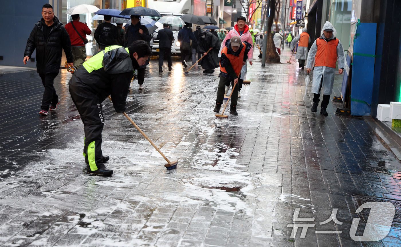 (서울=뉴스1) 김명섭 기자 = 18일 서울 중구 명동에서 중구청 직원 및 상인들이 오는 21일 열리는 BTS공연 및 봄철 관광객 맞이 물청소를 하고 있다.  2026.3.18/뉴 …