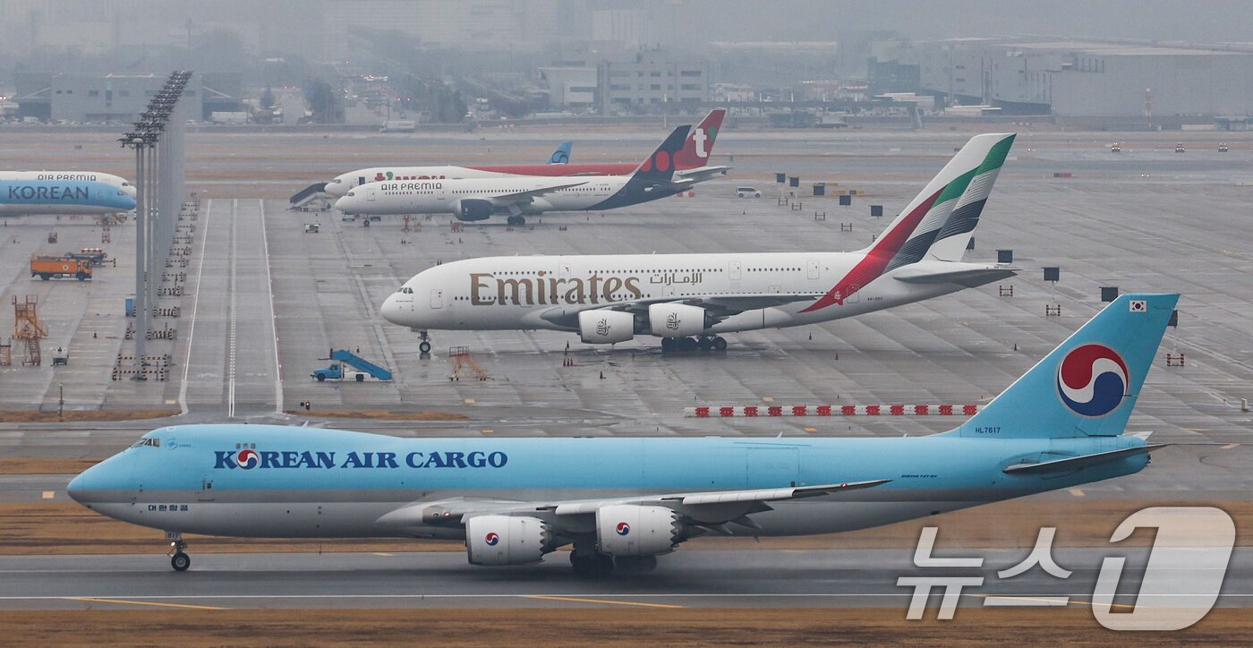 본문 이미지 - 중동 사태로 중동 경유 유럽행 항공 운항이 잇따라 취소되고 4월 국제선 항공권에 부과되는 유류할증료가 급등하며 장거리 여행 수요 둔화 전망이 나오고 있다. 사진은 18일 인천국제공항에 주기된 아랍에미리트(UAE) 국적기 에미레이트 항공기의 모습. 2026.3.18 ⓒ 뉴스1 최지환 기자