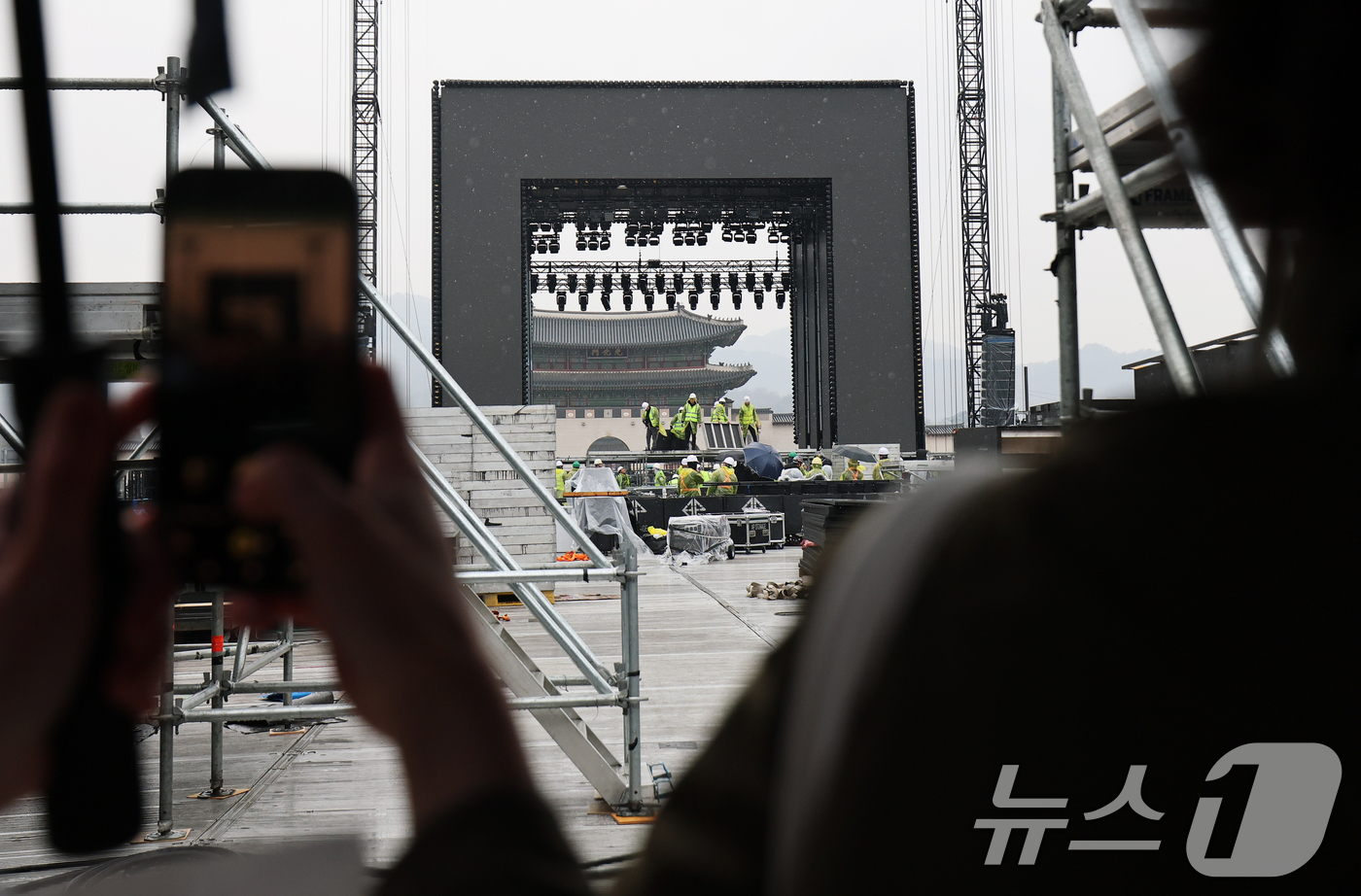 (서울=뉴스1) 오대일 기자 = 방탄소년단(BTS) 완전체 컴백 공연을 사흘 앞둔 18일 서울 광화문광장에서 외국인 팬들이 공연장 준비 상황을 스마트폰에 담고 있다.정부는 이날 방 …