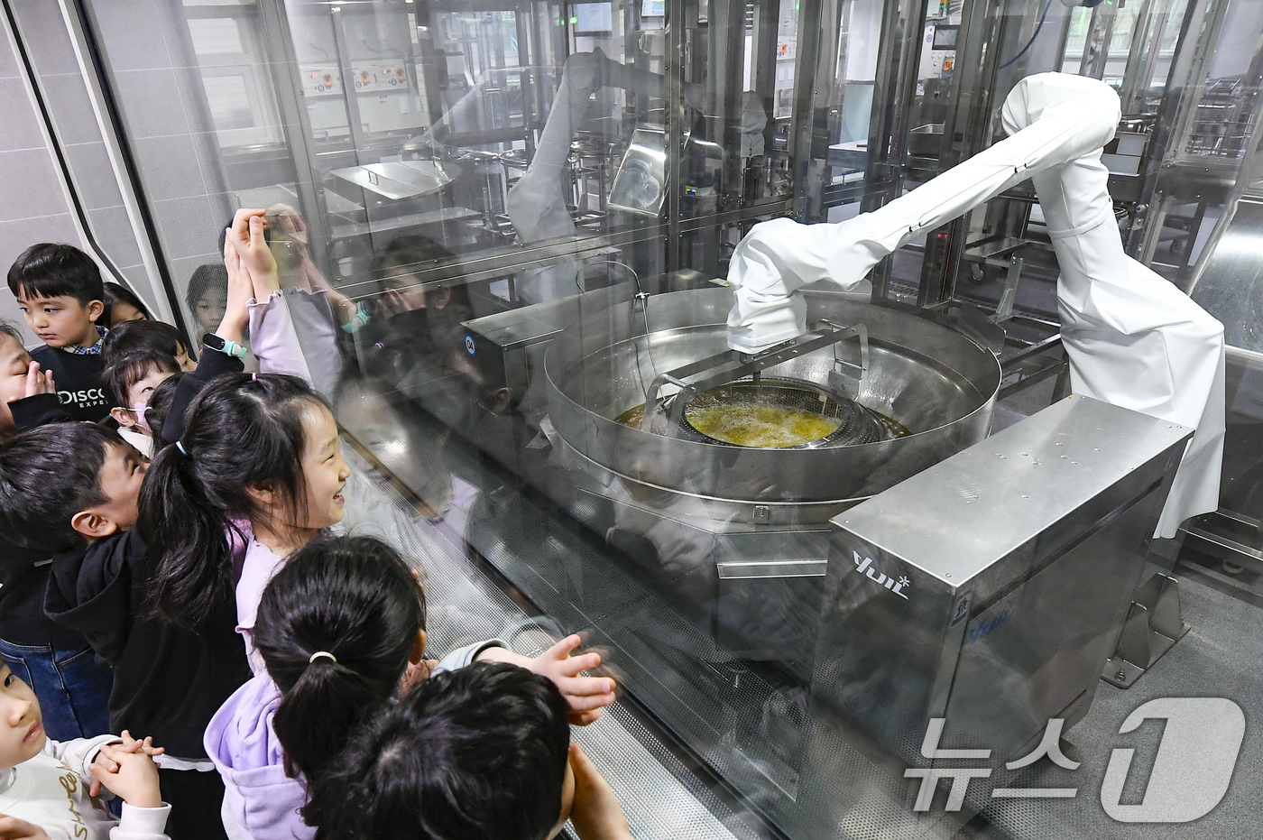 (수원=뉴스1) 김영운 기자 = 18일 경기 수원시 장안구 대평초등학교 내 위치한 거점형 학교급식 튀김 지원실에서 1학년 학생들이 튀김 조리 로봇이 직접 가동되는 현장을 보고 있다 …