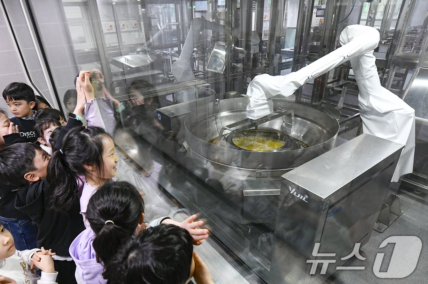 본문 이미지 - 18일 경기 수원시 장안구 대평초등학교 내 위치한 거점형 학교급식 튀김 지원실에서 1학년 학생들이 튀김 조리 로봇이 직접 가동되는 현장을 보고 있다. (공동취재) 2026.3.18 ⓒ 뉴스1 김영운 기자