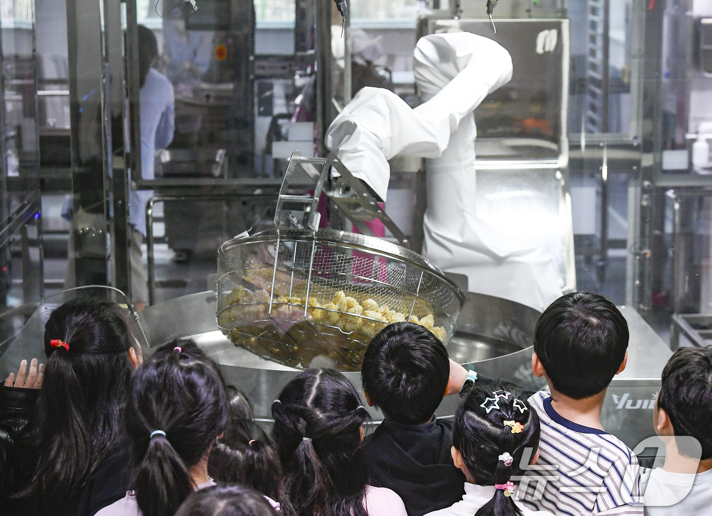 (수원=뉴스1) 김영운 기자 = 18일 경기 수원시 장안구 대평초등학교 내 위치한 거점형 학교급식 튀김 지원실에서 1학년 학생들이 튀김 조리 로봇이 직접 가동되는 현장을 보고 있다 …