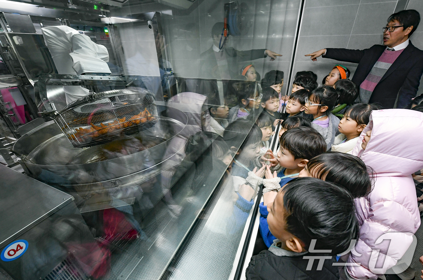 (수원=뉴스1) 김영운 기자 = 18일 경기 수원시 장안구 대평초등학교 내 위치한 거점형 학교급식 튀김 지원실에서 1학년 학생들이 튀김 조리 로봇이 직접 가동되는 현장을 보고 있다 …