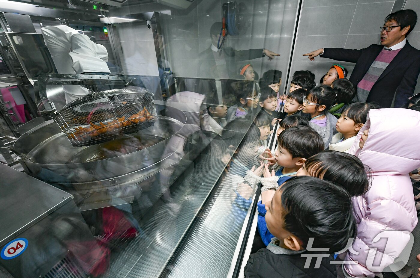 본문 이미지 - 18일 경기 수원시 장안구 대평초등학교 내 위치한 거점형 학교급식 튀김 지원실에서 1학년 학생들이 튀김 조리 로봇이 직접 가동되는 현장을 보고 있다. (공동취재) 2026.3.18 ⓒ 뉴스1 김영운 기자