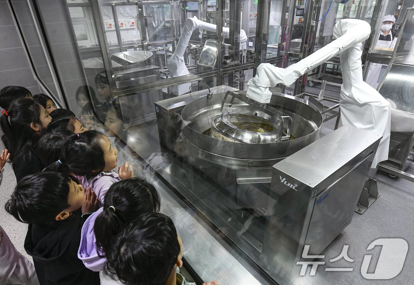 본문 이미지 - 18일 경기 수원시 장안구 대평초등학교 내 위치한 거점형 학교급식 튀김 지원실에서 1학년 학생들이 튀김 조리 로봇이 직접 가동되는 현장을 보고 있다. (공동취재) 2026.3.18 ⓒ 뉴스1 김영운 기자