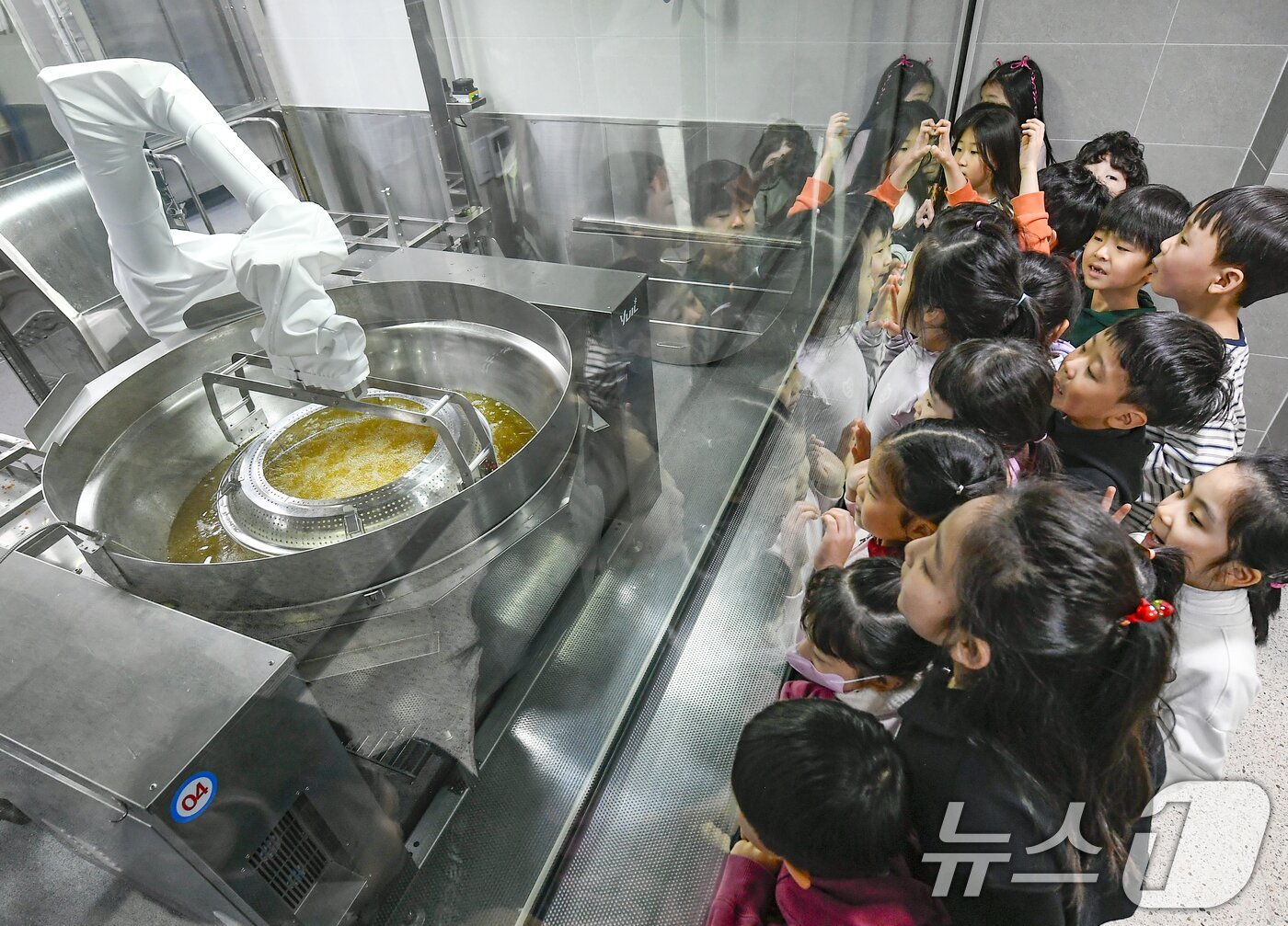 본문 이미지 - 18일 경기 수원시 장안구 대평초등학교 내 위치한 거점형 학교급식 튀김 지원실에서 1학년 학생들이 튀김 조리 로봇이 직접 가동되는 현장을 보고 있다. (공동취재) 2026.3.18 ⓒ 뉴스1 김영운 기자