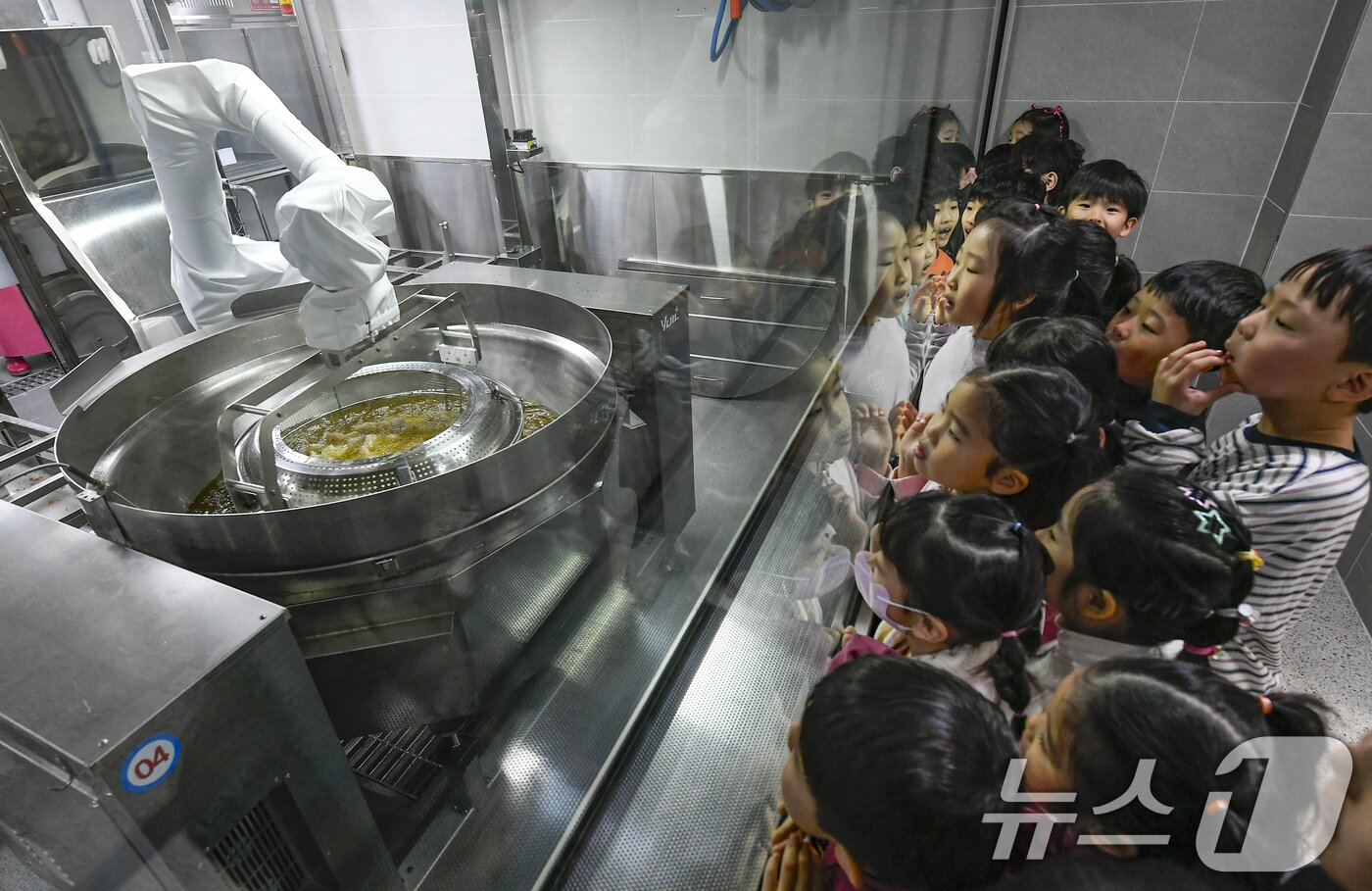 본문 이미지 - 18일 경기 수원시 장안구 대평초등학교 내 위치한 거점형 학교급식 튀김 지원실에서 1학년 학생들이 튀김 조리 로봇이 직접 가동되는 현장을 보고 있다. (공동취재) 2026.3.18 ⓒ 뉴스1 김영운 기자