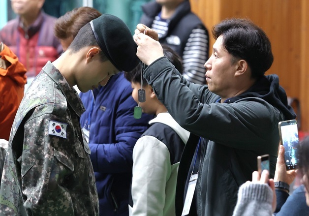 아들에게 인식표 걸어주는 아버지