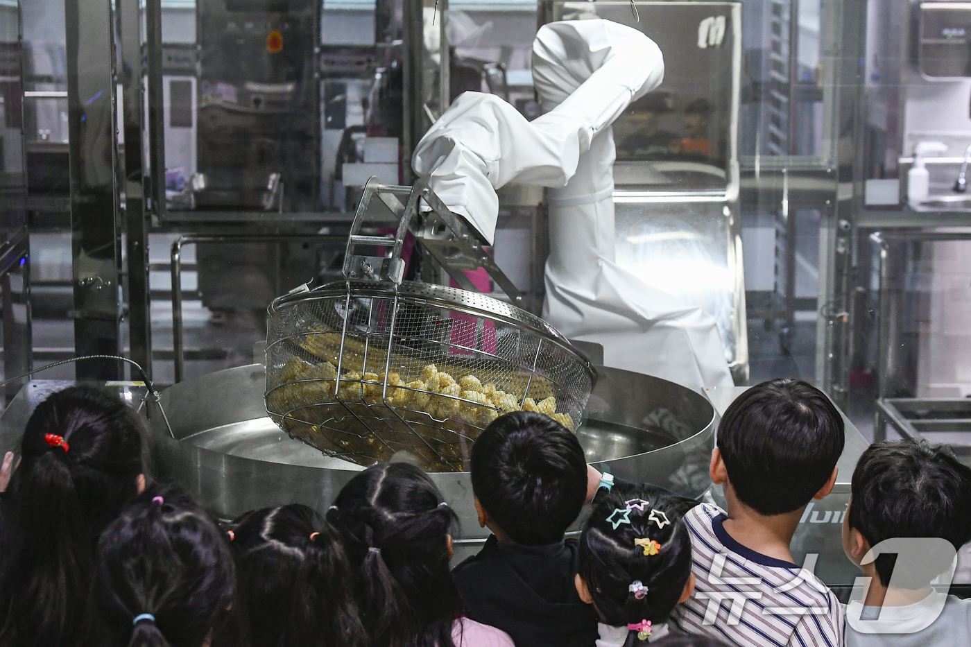 (수원=뉴스1) 김영운 기자 = 18일 경기 수원시 장안구 대평초등학교 내 위치한 거점형 학교급식 튀김 지원실에서 1학년 학생들이 튀김 조리 로봇이 직접 가동되는 현장을 보고 있다 …