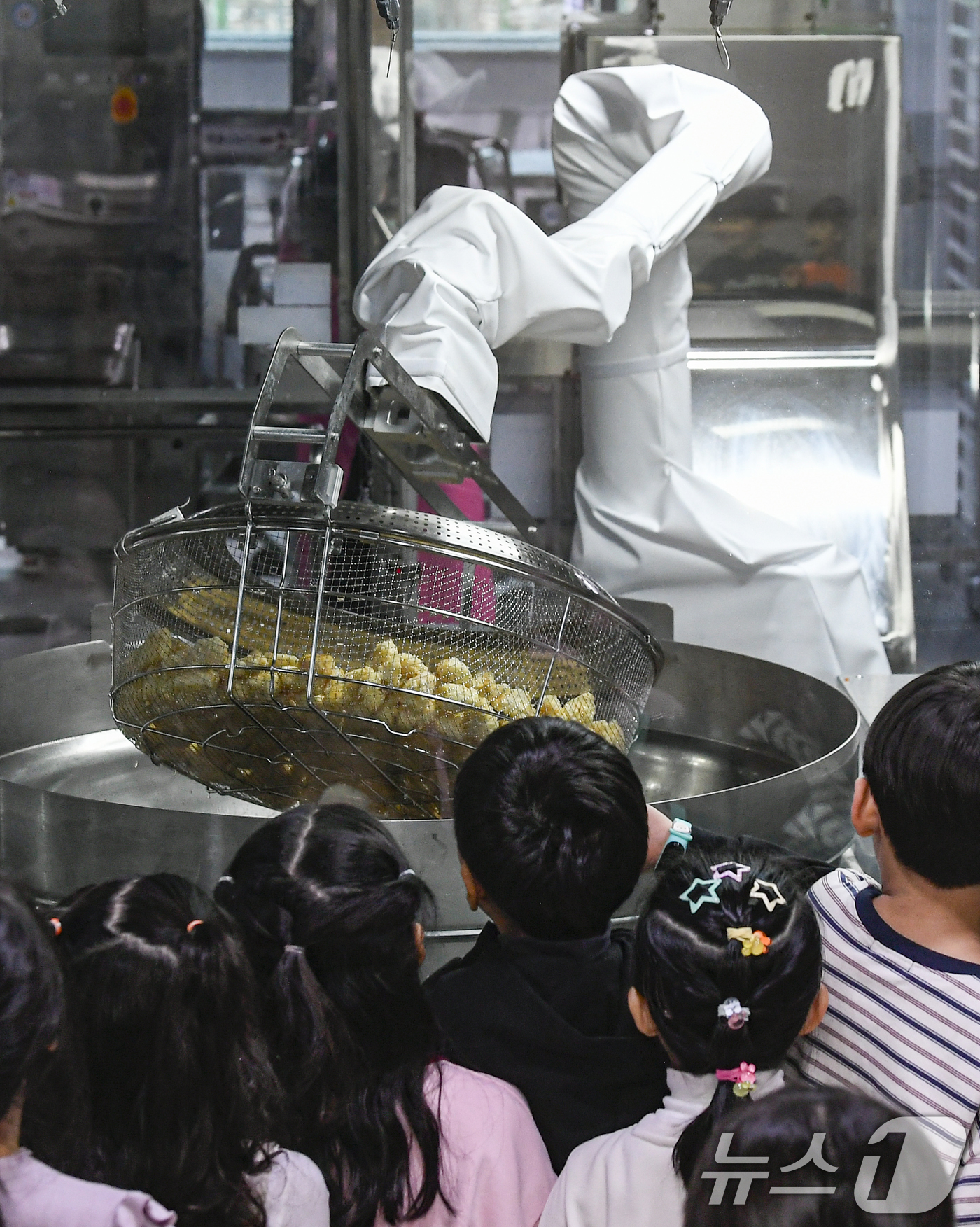 (수원=뉴스1) 김영운 기자 = 18일 경기 수원시 장안구 대평초등학교 내 위치한 거점형 학교급식 튀김 지원실에서 1학년 학생들이 튀김 조리 로봇이 직접 가동되는 현장을 보고 있다 …