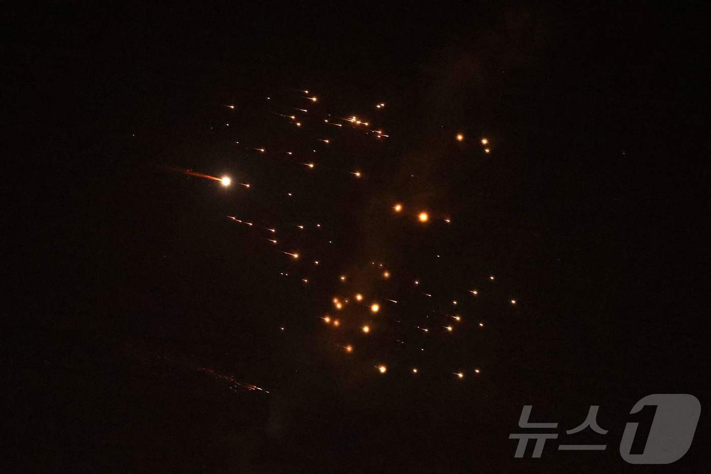 본문 이미지 - 18일(현지시간) 이스라엘 해안도시 네타냐 상공에서 이란의 새로운 미사일 일제 사격이 이어지지는 상황에서 로켓 궤적들이 하늘에 포착됐다. 2026.03.18. ⓒ AFP=뉴스1