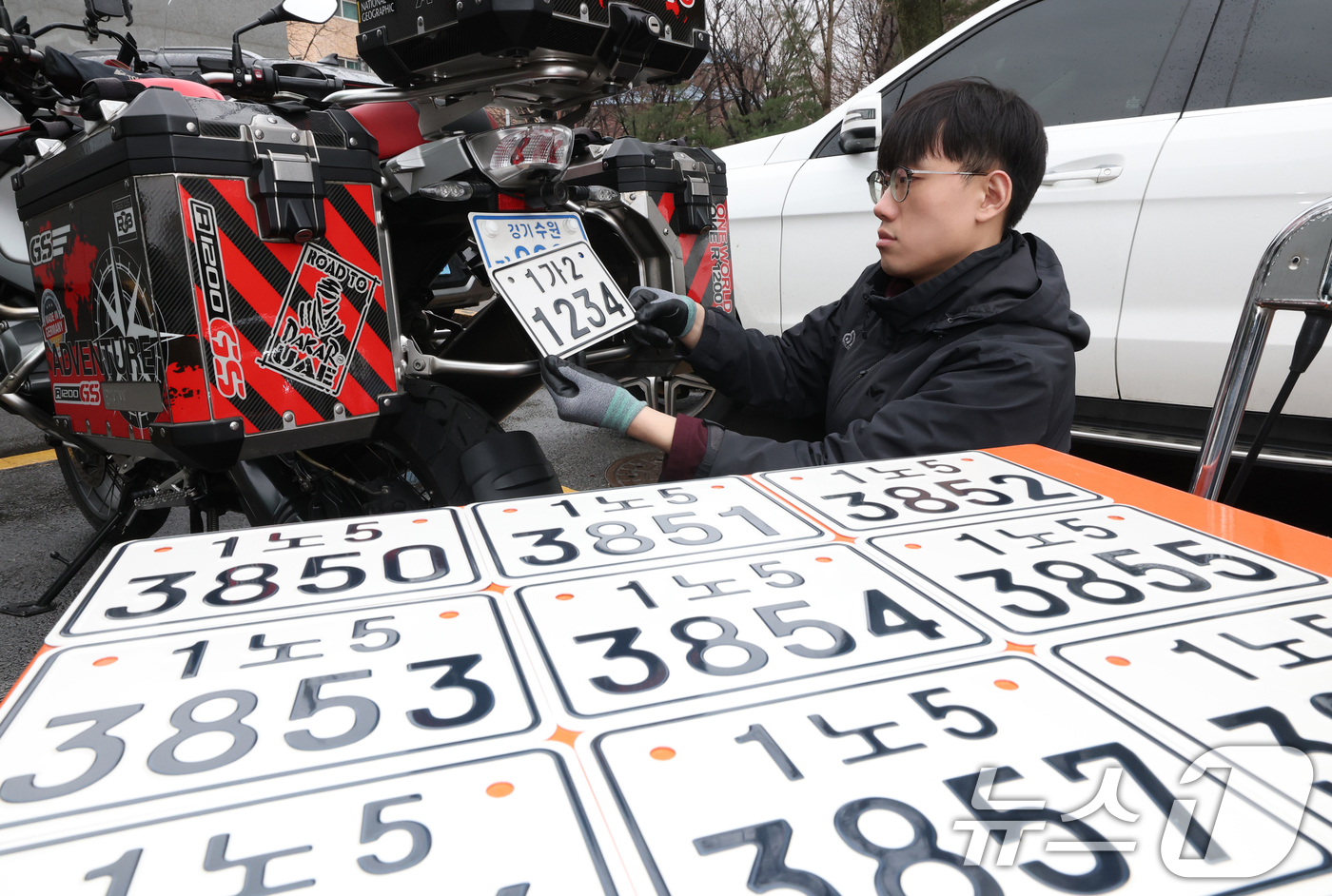 (수원=뉴스1) 김영운 기자 = 이륜자동차 전국 번호판 제도 시행을 이틀 앞둔 18일 경기 수원시 권선구 수원도시공사 번호판제작소에서 관계자가 번호판 교체 시연을을 하고 있다.새롭 …
