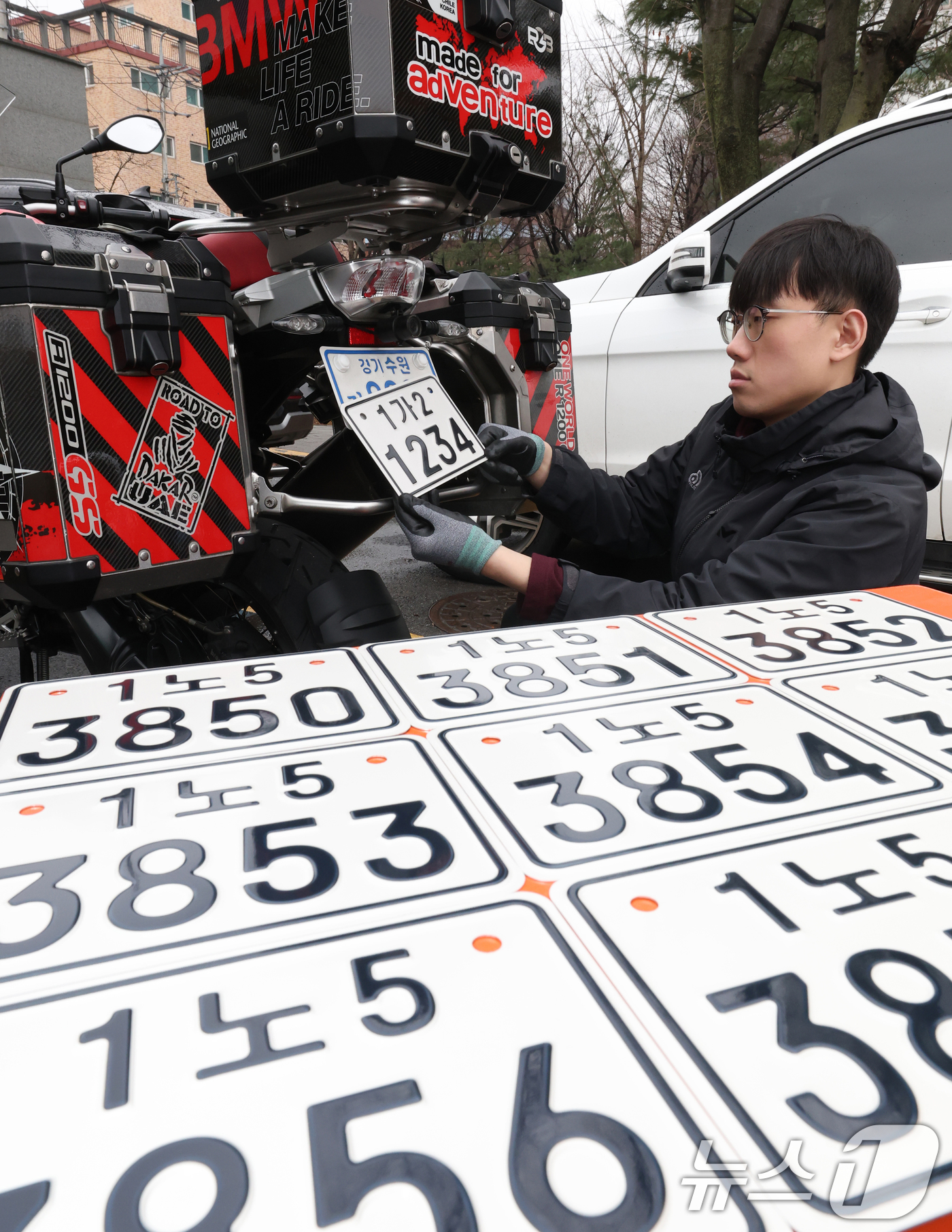 (수원=뉴스1) 김영운 기자 = 이륜자동차 전국 번호판 제도 시행을 이틀 앞둔 18일 경기 수원시 권선구 수원도시공사 번호판제작소에서 관계자가 번호판 교체 시연을을 하고 있다.새롭 …