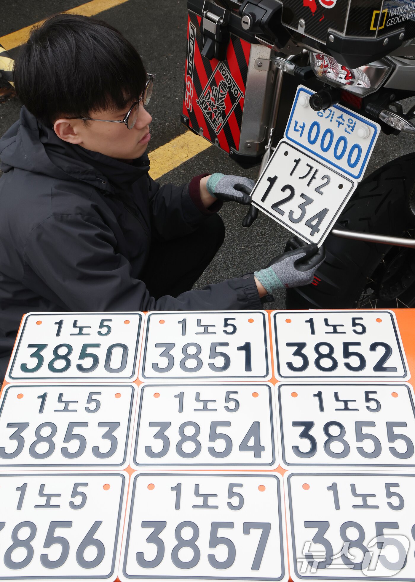 본문 이미지 - 이륜자동차 전국 번호판 제도 시행을 이틀 앞둔 18일 경기 수원시 권선구 수원도시공사 번호판제작소에서 관계자가 번호판 교체 시연을을 하고 있다.  ⓒ 뉴스1 김영운 기자