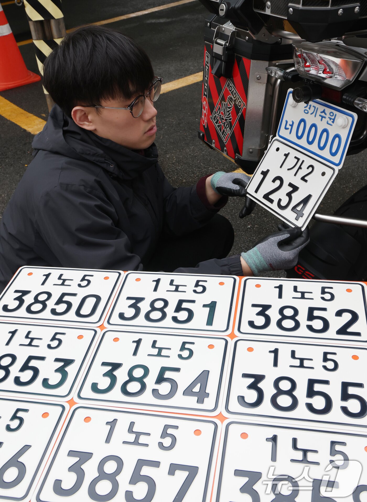 본문 이미지 - 이륜자동차 전국 번호판 제도 시행을 이틀 앞둔 18일 경기 수원시 권선구 수원도시공사 번호판제작소에서 관계자가 번호판 교체 시연을을 하고 있다.  ⓒ 뉴스1 김영운 기자