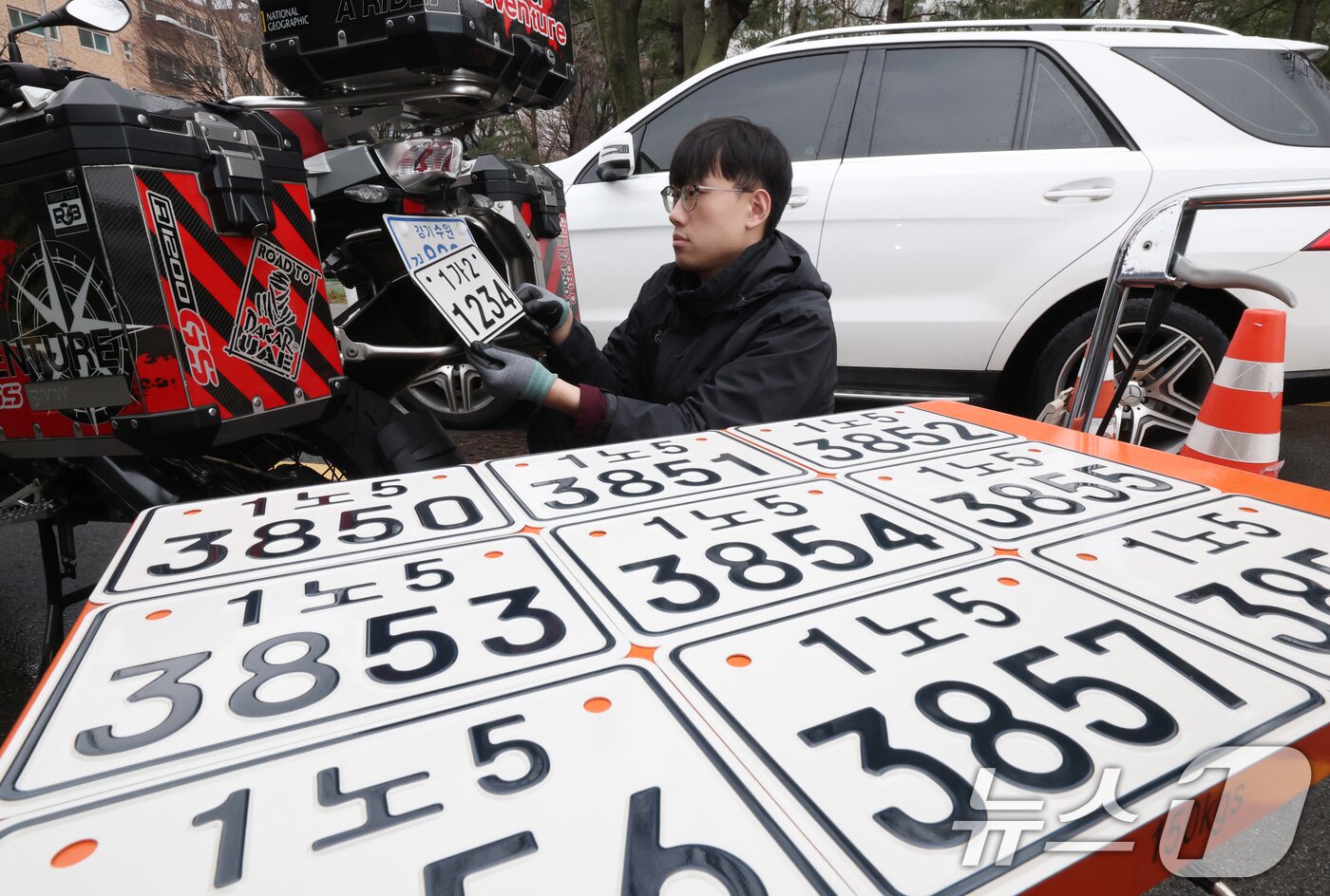 본문 이미지 - 이륜자동차 전국 번호판 제도 시행을 이틀 앞둔 18일 경기 수원시 권선구 수원도시공사 번호판제작소에서 관계자가 번호판 교체 시연을을 하고 있다.  ⓒ 뉴스1 김영운 기자
