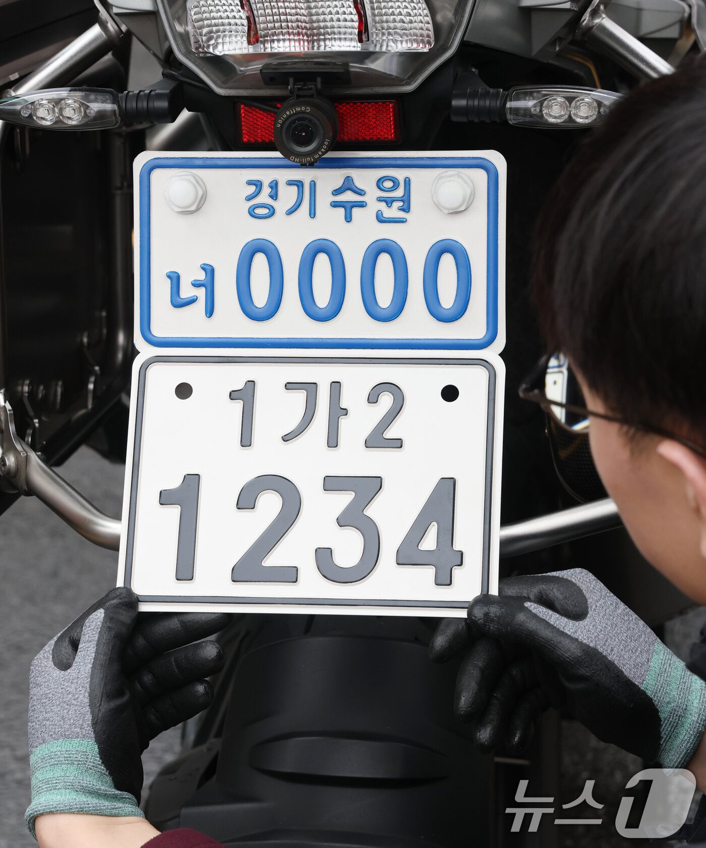 본문 이미지 - 이륜자동차 전국 번호판 제도 시행을 이틀 앞둔 18일 경기 수원시 권선구 수원도시공사 번호판제작소에서 관계자가 번호판 교체 시연을을 하고 있다.  ⓒ 뉴스1 김영운 기자