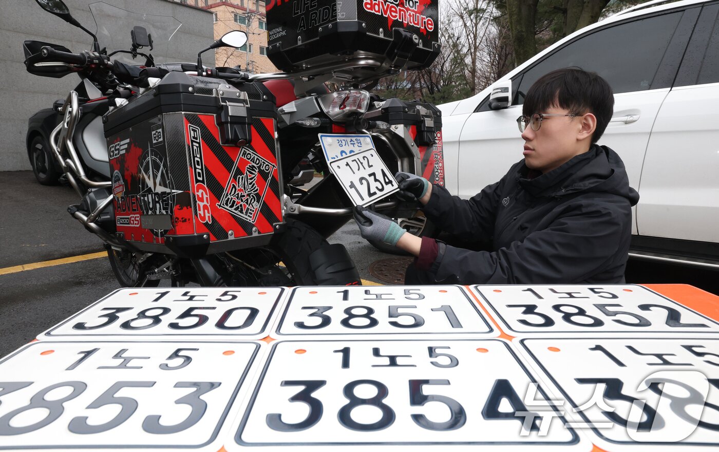 본문 이미지 - 이륜자동차 전국 번호판 제도 시행을 이틀 앞둔 18일 경기 수원시 권선구 수원도시공사 번호판제작소에서 관계자가 번호판 교체 시연을을 하고 있다.  ⓒ 뉴스1 김영운 기자