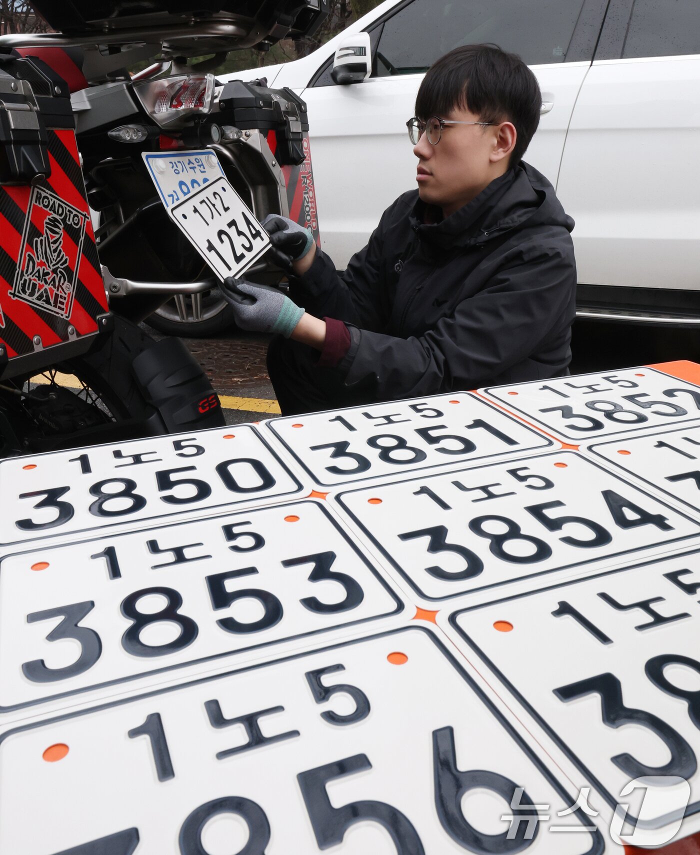 본문 이미지 - 이륜자동차 전국 번호판 제도 시행을 이틀 앞둔 18일 경기 수원시 권선구 수원도시공사 번호판제작소에서 관계자가 번호판 교체 시연을을 하고 있다.  ⓒ 뉴스1 김영운 기자