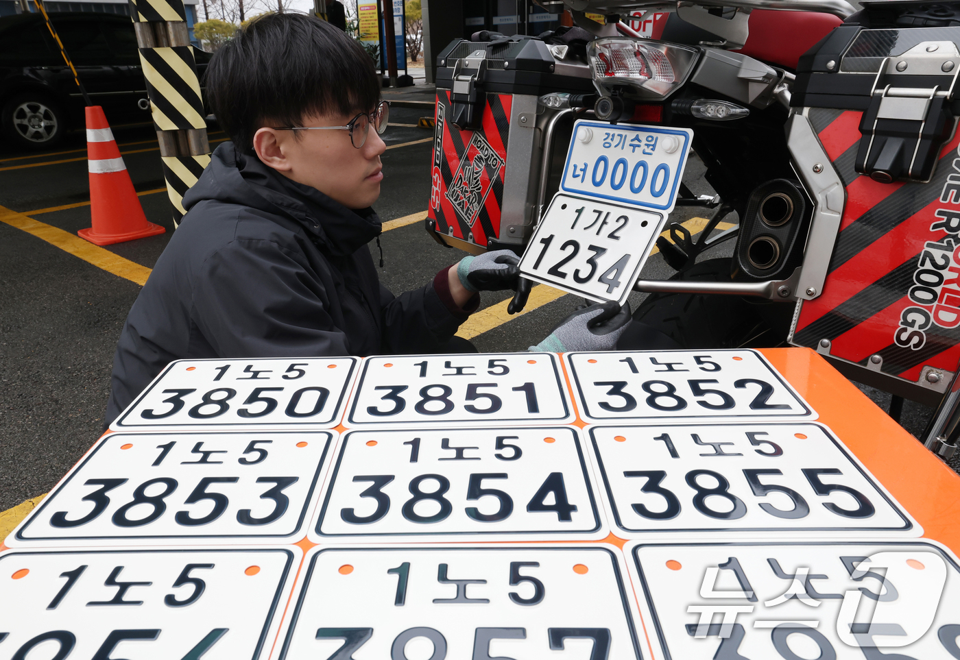 (수원=뉴스1) 김영운 기자 = 이륜자동차 전국 번호판 제도 시행을 이틀 앞둔 18일 경기 수원시 권선구 수원도시공사 번호판제작소에서 관계자가 번호판 교체 시연을을 하고 있다.새롭 …