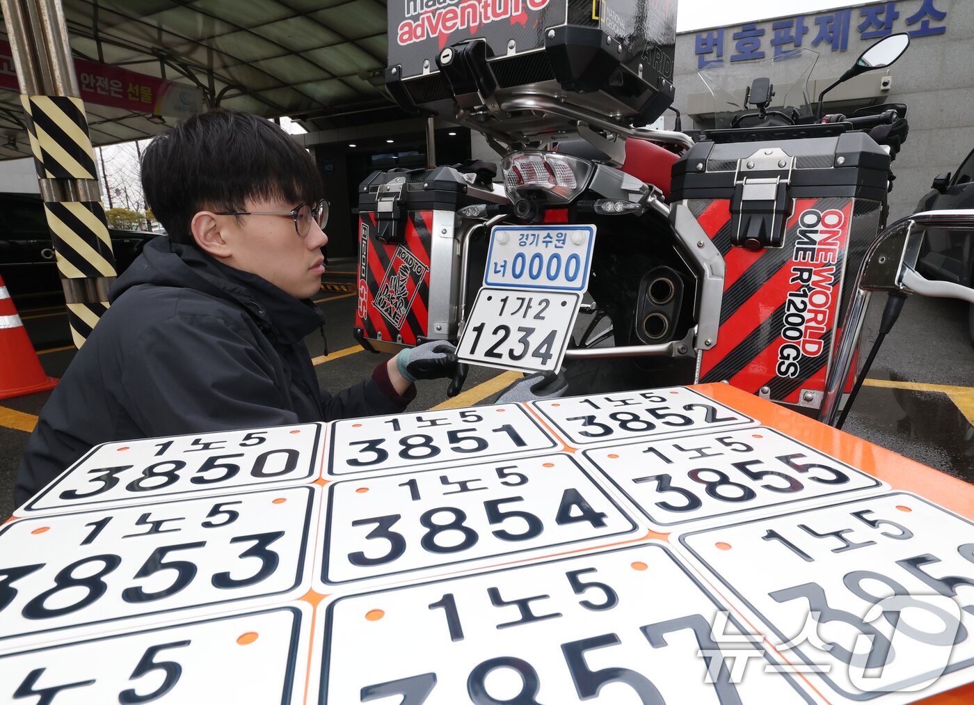 본문 이미지 - 이륜자동차 전국 번호판 제도 시행을 이틀 앞둔 18일 경기 수원시 권선구 수원도시공사 번호판제작소에서 관계자가 번호판 교체 시연을을 하고 있다.  ⓒ 뉴스1 김영운 기자