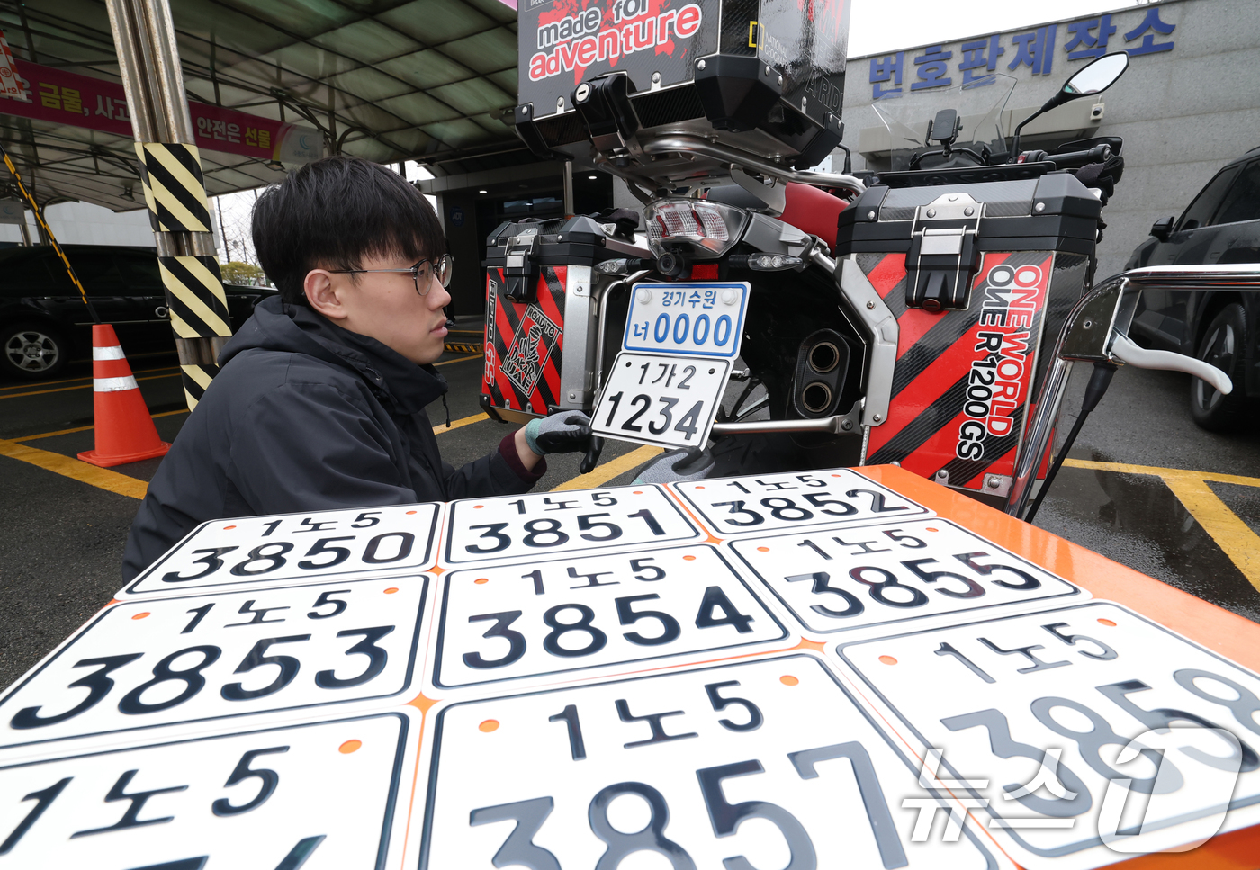 (수원=뉴스1) 김영운 기자 = 이륜자동차 전국 번호판 제도 시행을 이틀 앞둔 18일 경기 수원시 권선구 수원도시공사 번호판제작소에서 관계자가 번호판 교체 시연을을 하고 있다.새롭 …