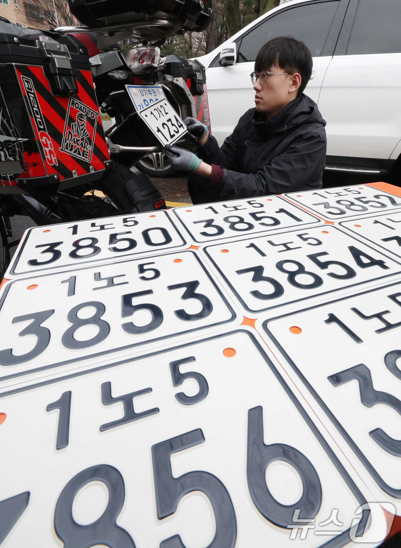 (수원=뉴스1) 김영운 기자 = 이륜자동차 전국 번호판 제도 시행을 이틀 앞둔 18일 경기 수원시 권선구 수원도시공사 번호판제작소에서 관계자가 번호판 교체 시연을을 하고 있다.새롭 …