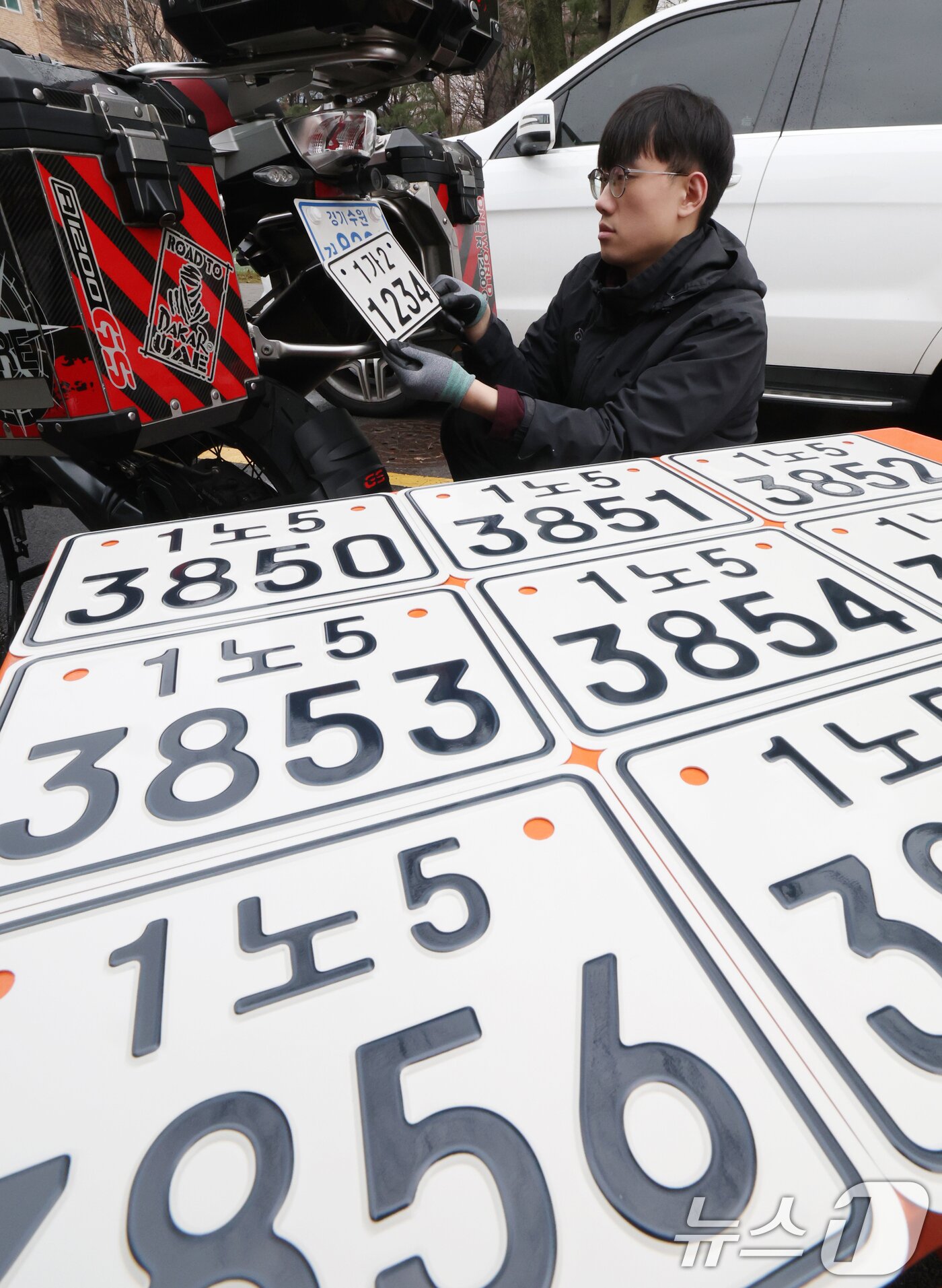 본문 이미지 - 이륜자동차 전국 번호판 제도 시행을 이틀 앞둔 18일 경기 수원시 권선구 수원도시공사 번호판제작소에서 관계자가 번호판 교체 시연을을 하고 있다.  ⓒ 뉴스1 김영운 기자