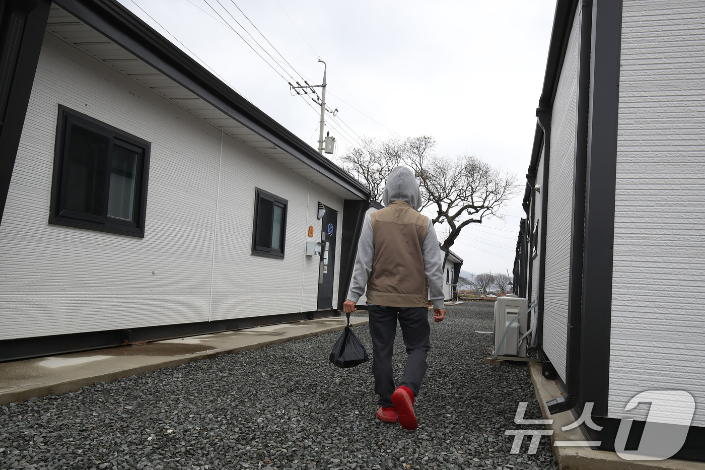 (안동=뉴스1) 공정식 기자 = 18일 경북 안동시 일직면의 한 임시주거용 조립주택에서 산불 피해 이재민이 음식 꾸러미를 들고 집으로 가고 있다. 2026.3.18/뉴스1