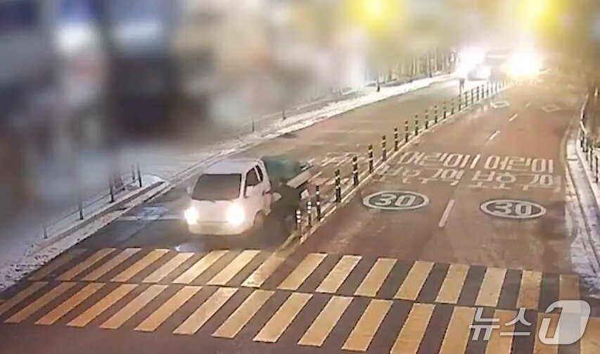 본문 이미지 - 양명덕 씨가 운전자 없이 도로 위를 미끄러지던 1톤 화물차를 세우려고 올라타는 모습. (사진 및 영상=경기북부경찰청) ⓒ News1