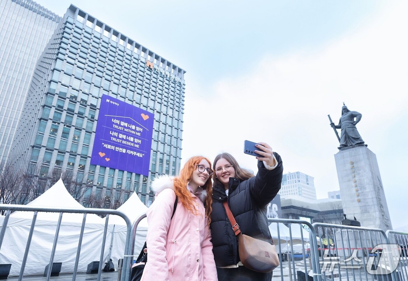 본문 이미지 - 맞은편에 위치한 현대해상도 본사 사옥 전면에 BTS 노래 가사와 보험업의 본질인 '신뢰와 안전'의 의미를 결합한 대형 현수막을 내걸었다./사진제공=현대해상