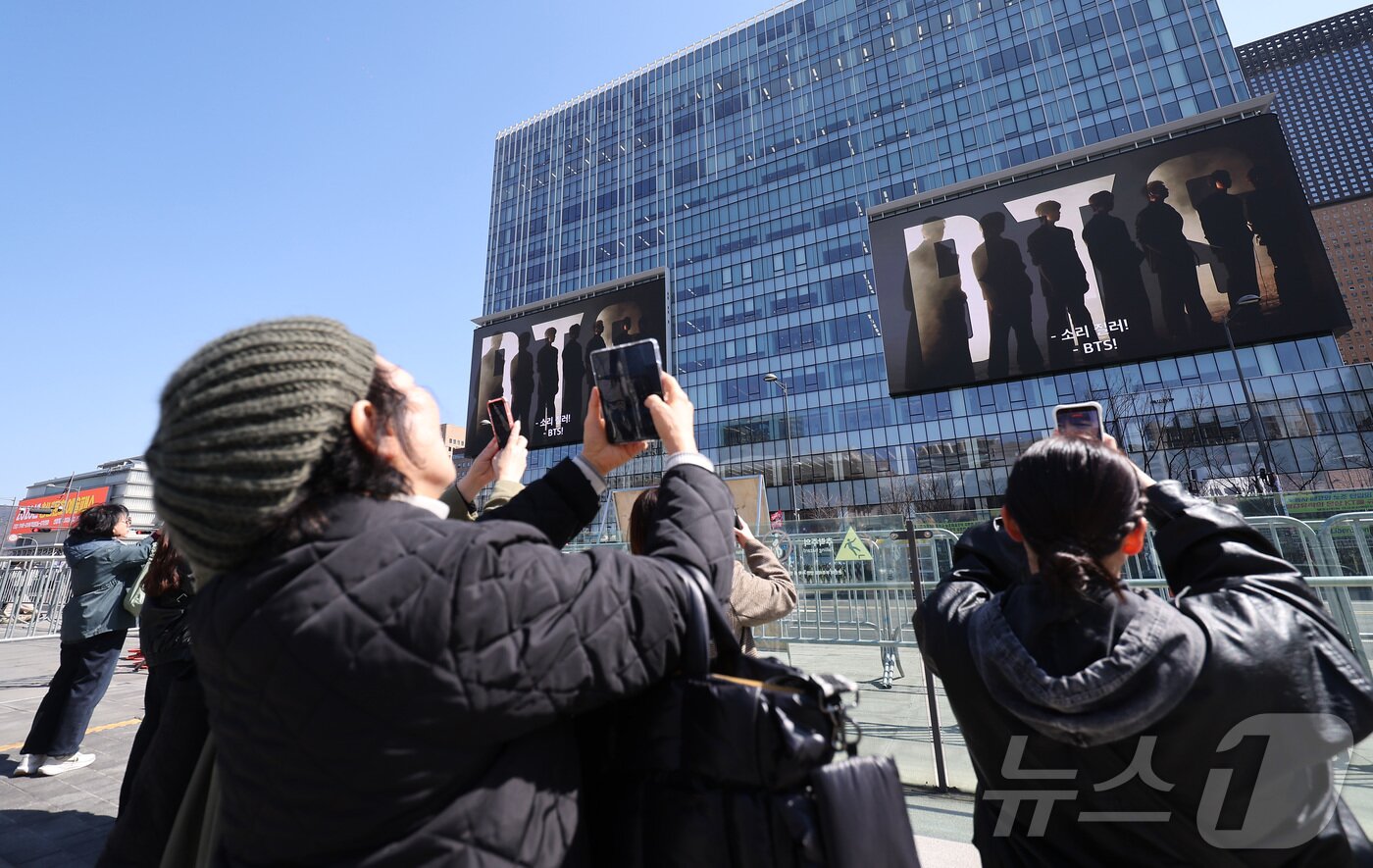 본문 이미지 - 방탄소년단(BTS)의 서울 광화문광장 컴백 공연이 이틀 앞으로 다가온 19일 서울 종로구 광화문광장에서 외국인 팬들이 컴백 공연을 알리는 전광판 광고를 스마트폰으로 촬영하고 있다. ⓒ 뉴스1 김성진 기자