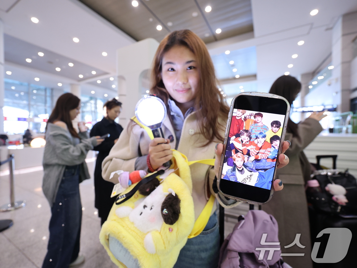 (인천공항=뉴스1) 박지혜 기자 = 19일 인천국제공항에서 BTS 팬클럽 ‘아미’인 중국인 클로이(20)가 입국하며 아미밤(방탄소년단 공식 응원봉)과 멤버들의 사진을 들어 보이고 …