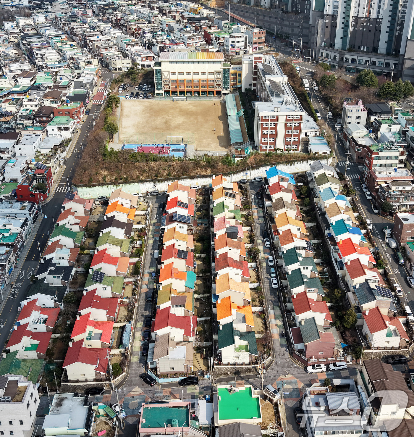 (부산=뉴스1) 윤일지 기자 = 방탄소년단(BTS) 컴백 공연을 이틀 앞둔 19일 부산 북구 만덕 레고마을의 알록달록한 지붕들이 줄지어 있다. 뒤로는 정국이 다녔던 백양중학교가 보 …