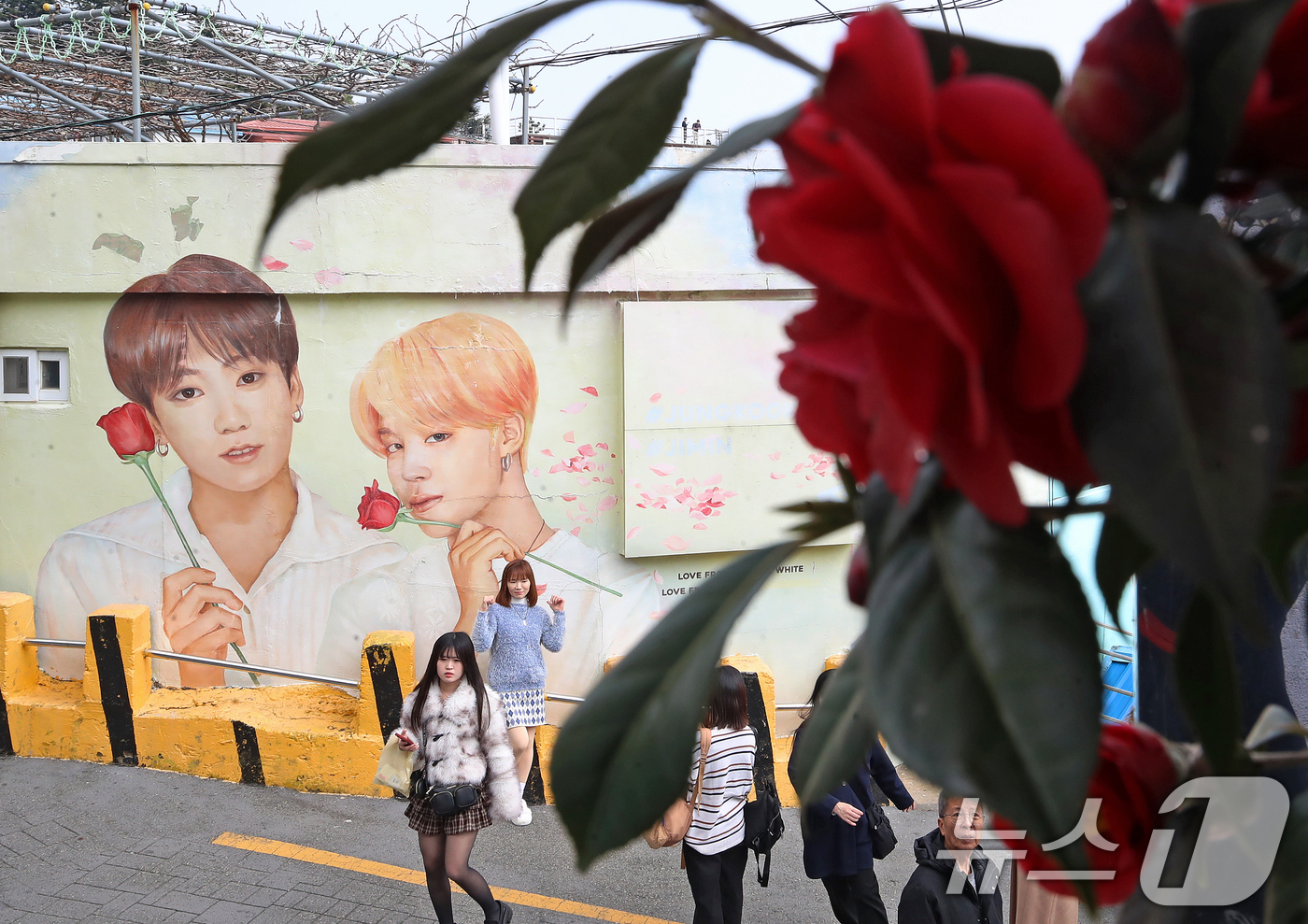 (부산=뉴스1) 윤일지 기자 = 방탄소년단(BTS) 컴백 공연을 이틀 앞둔 19일 부산 서구 감천문화마을에서 외국인 관광객들이 부산이 고향인 BTS 멤버 정국·지민이 그려진 대형 …