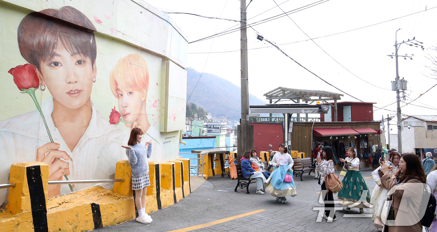 (부산=뉴스1) 윤일지 기자 = 방탄소년단(BTS) 컴백 공연을 이틀 앞둔 19일 부산 서구 감천문화마을에서 외국인 관광객들이 부산이 고향인 BTS 멤버 정국·지민이 그려진 대형 …