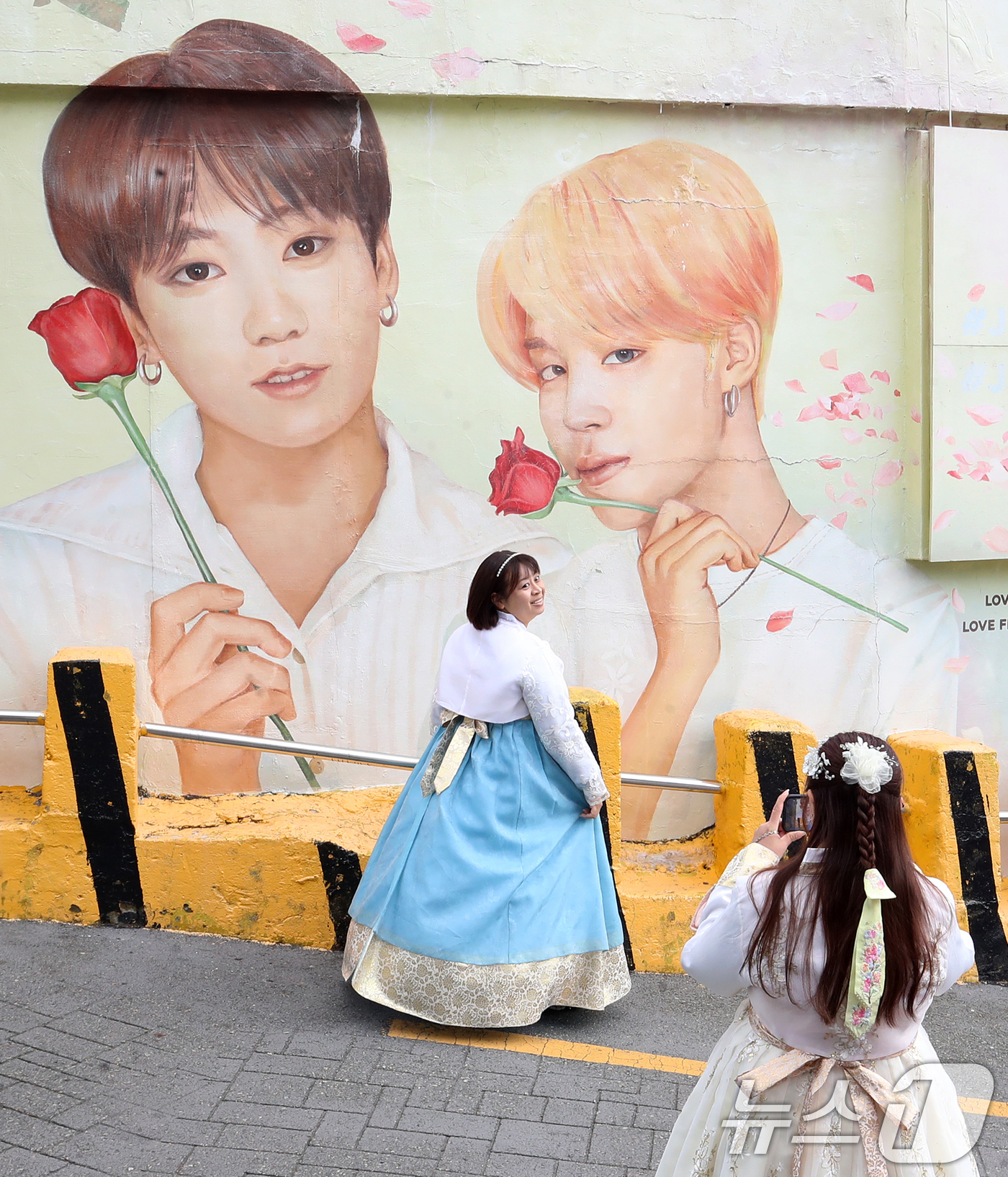 (부산=뉴스1) 윤일지 기자 = 방탄소년단(BTS) 컴백 공연을 이틀 앞둔 19일 부산 서구 감천문화마을에서 외국인 관광객들이 부산이 고향인 BTS 멤버 정국·지민이 그려진 대형 …