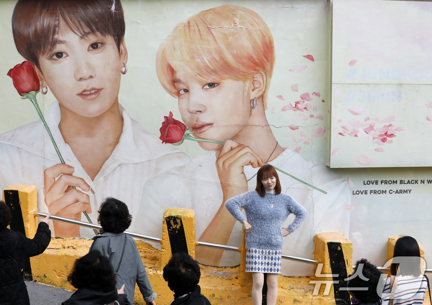 (부산=뉴스1) 윤일지 기자 = 방탄소년단(BTS) 컴백 공연을 이틀 앞둔 19일 부산 서구 감천문화마을에서 외국인 관광객들이 부산이 고향인 BTS 멤버 정국·지민이 그려진 대형 …