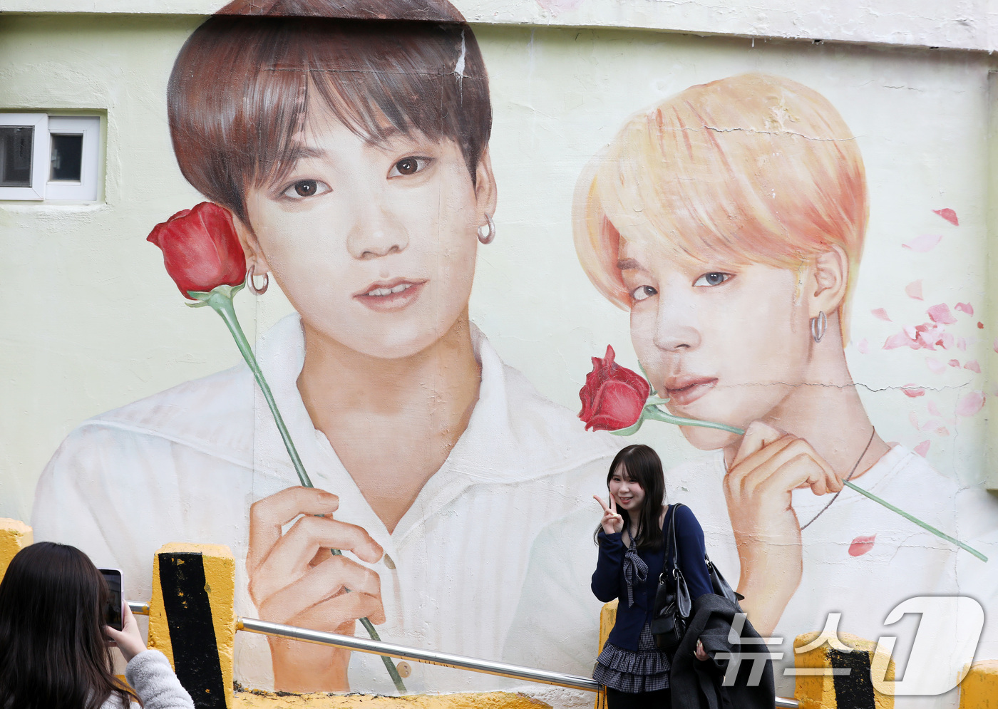 (부산=뉴스1) 윤일지 기자 = 방탄소년단(BTS) 컴백 공연을 이틀 앞둔 19일 부산 서구 감천문화마을에서 외국인 관광객들이 부산이 고향인 BTS 멤버 정국·지민이 그려진 대형 …